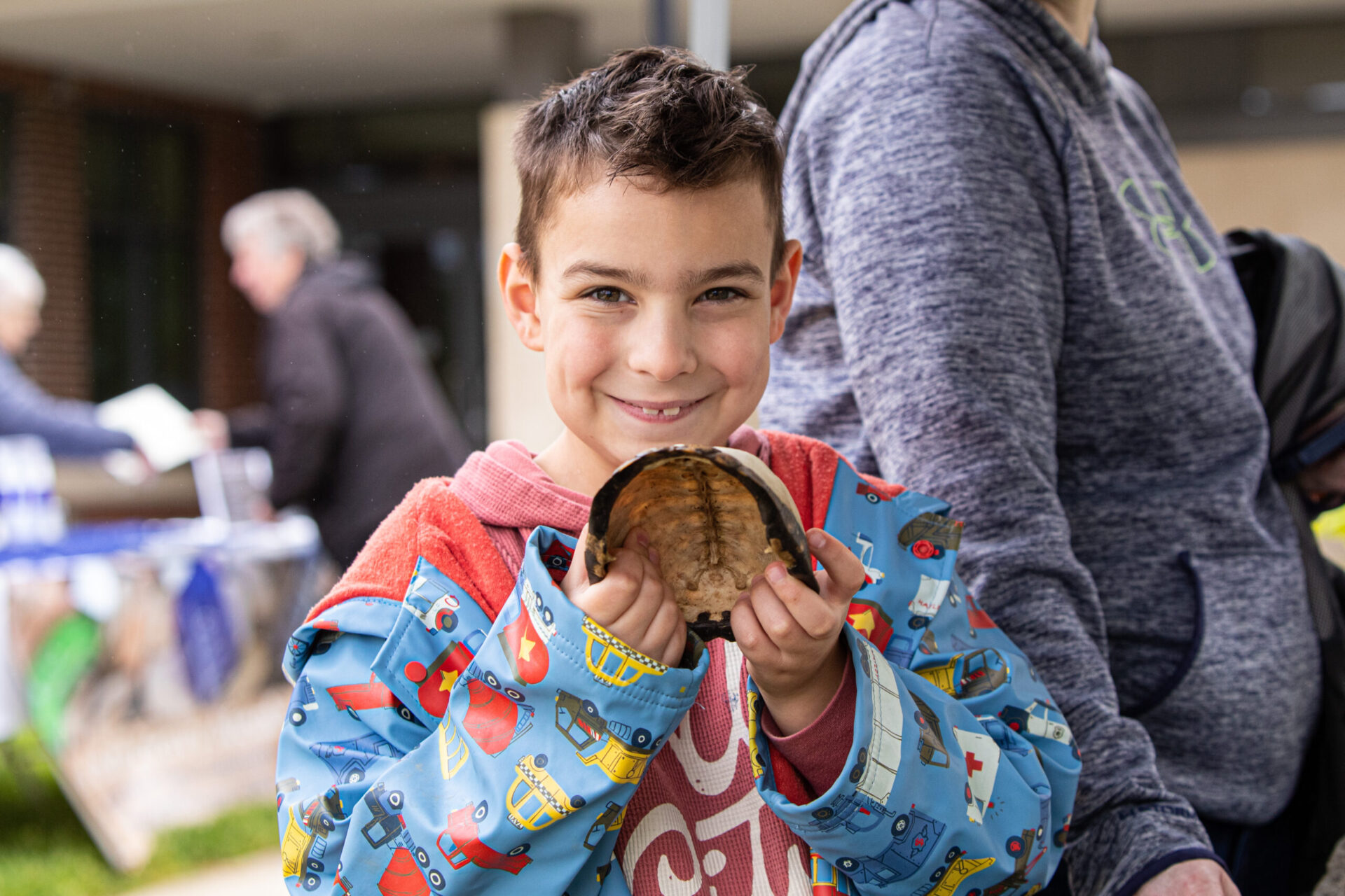 a young boy holding a piece of food in his hands.